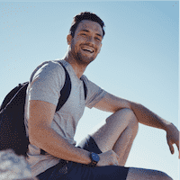 Anthony in athletic clothing and a backpack sitting on a rock Anthony in athletic clothing and a backpack sitting on a rock