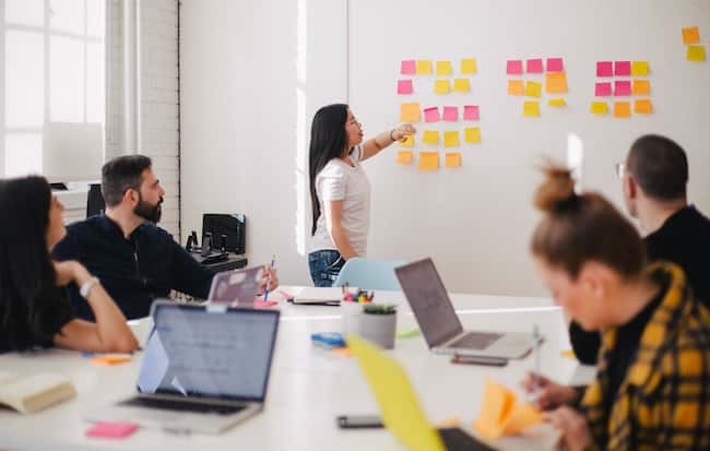 A woman instructing a workshop with her team in an office A woman instructing a workshop with her team in an office
