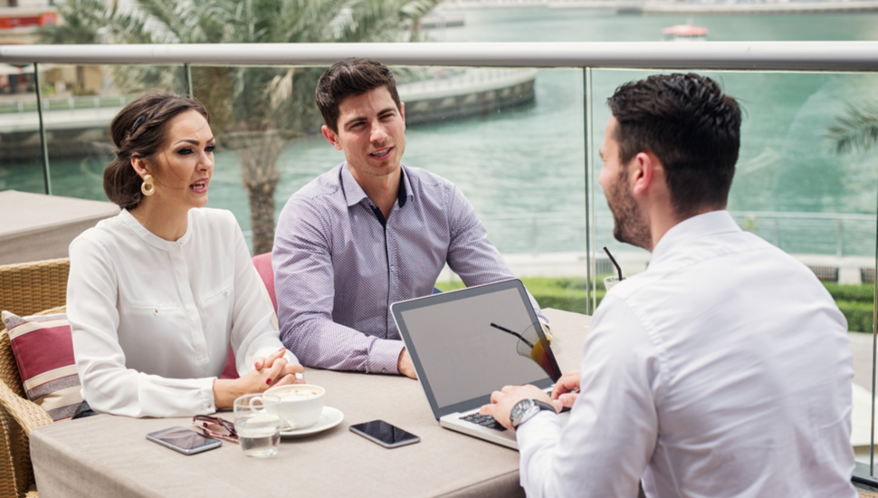 two coworkers discussing a deal with a salesman in the middle east