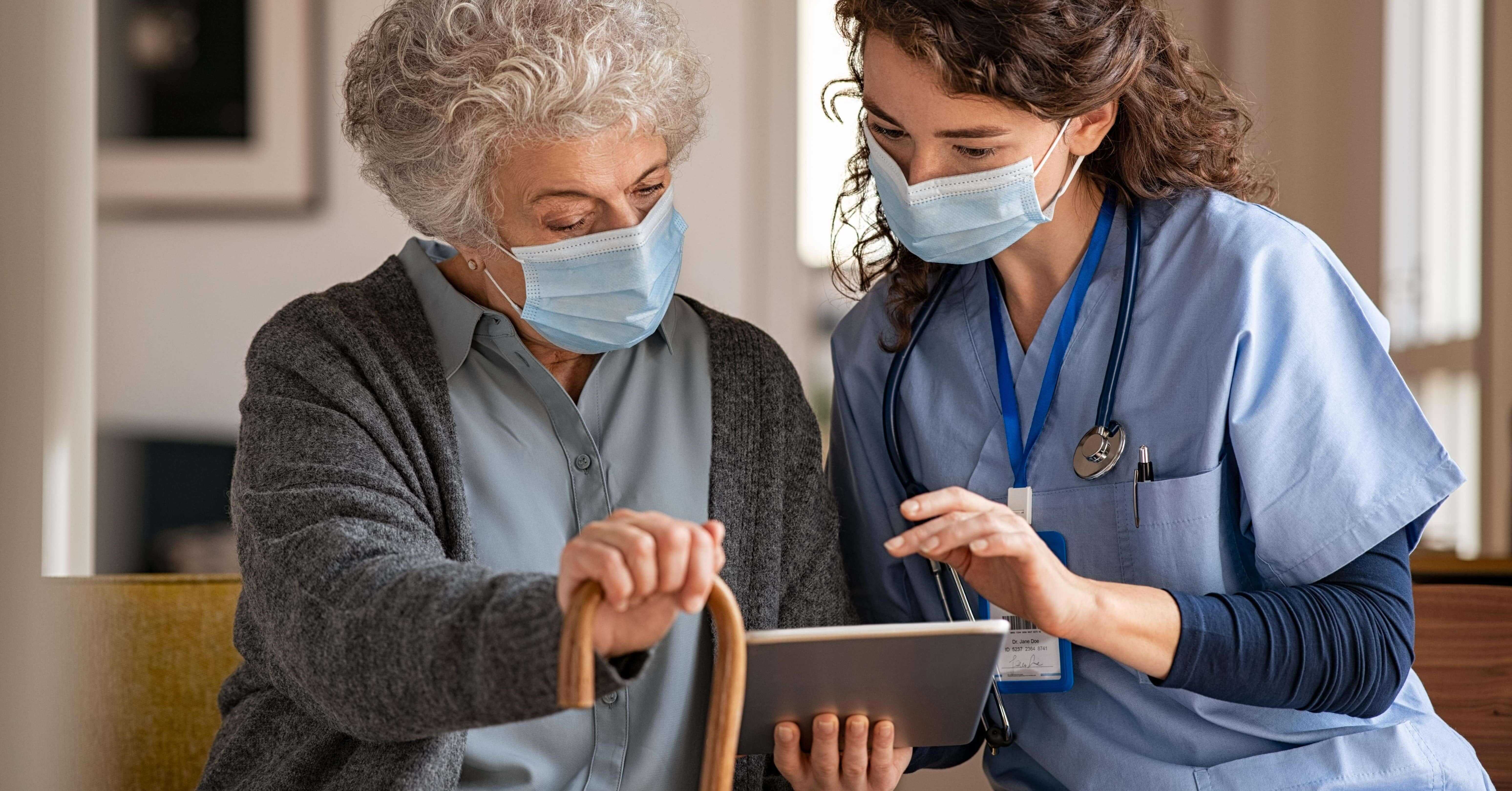 nurse and care home resident using a tablet