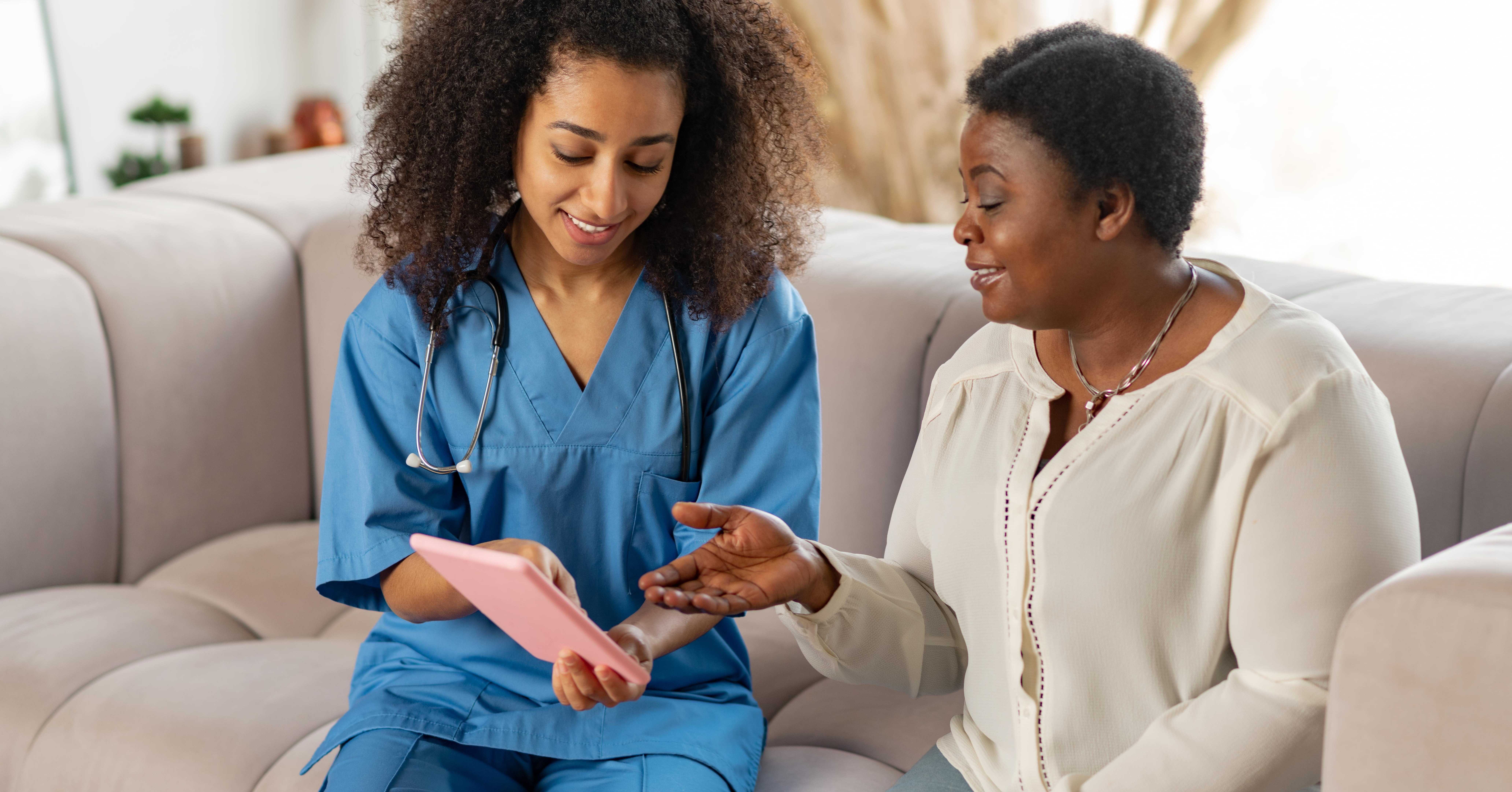nurse shows resident in care home ways technology can improve the quality of care