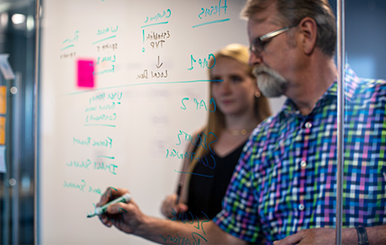 nvisia colleagues brainstorming on glass window