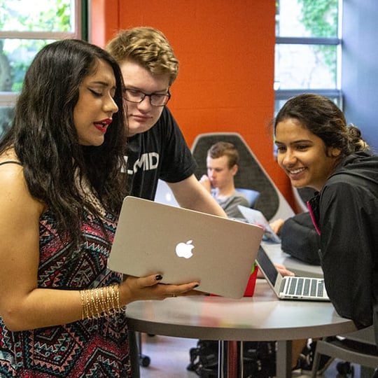 Students looking at laptop