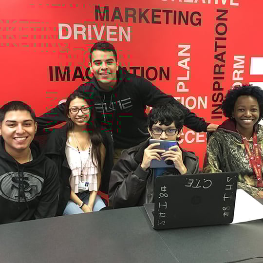 students gathered around a laptop