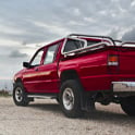 red pickup truck parked near body of water