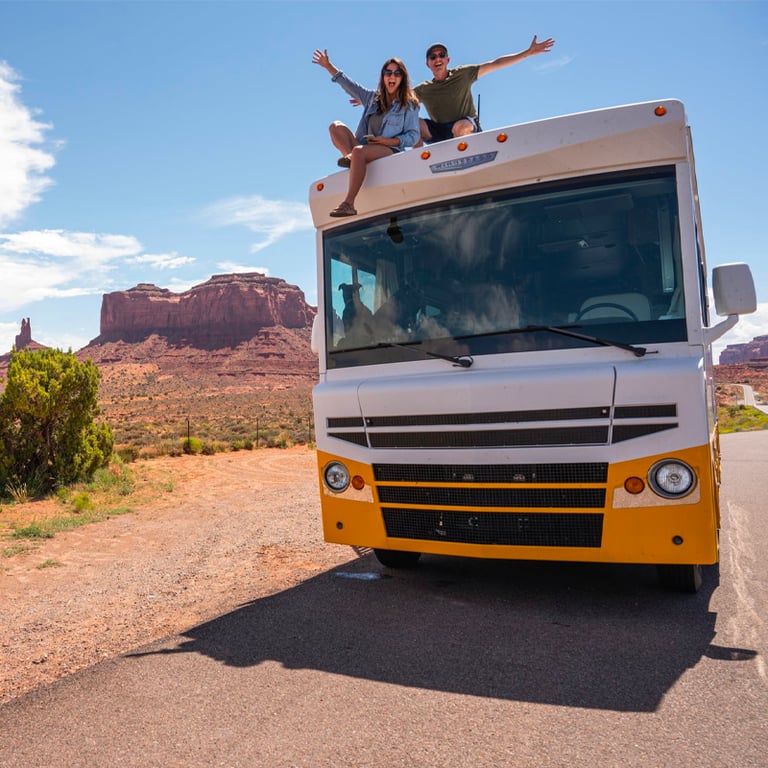 yellow and white bus on road with couple sitting on roof