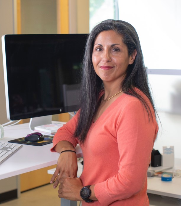 Woman Standing At Computer Smiling