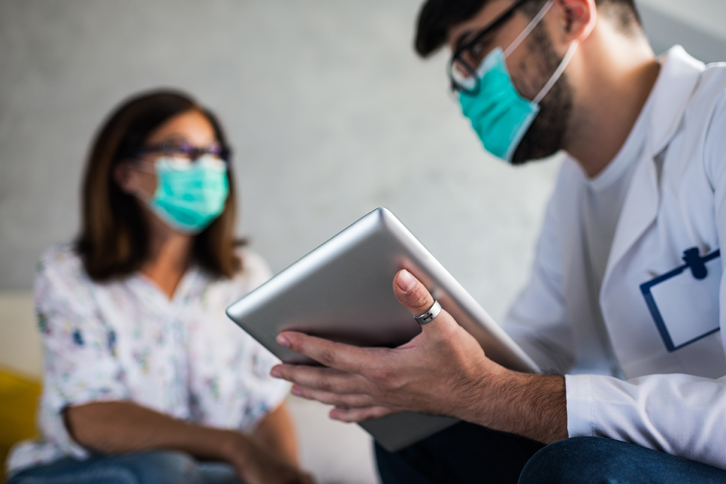 masked doctor using ipad