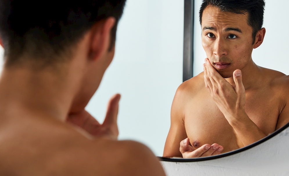 Man checking his face in the mirror