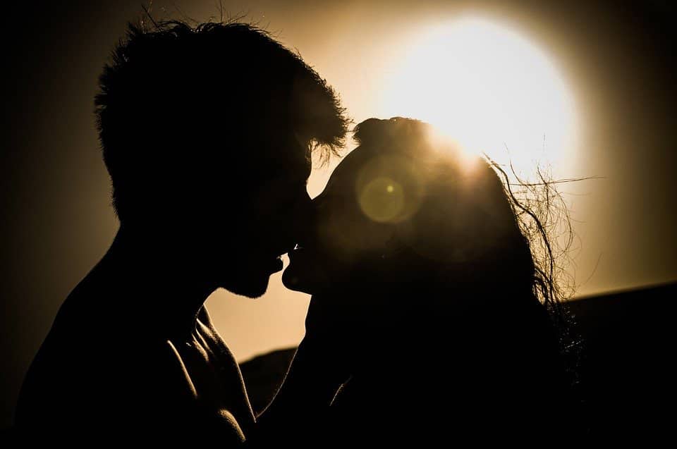 Silhouetted couple kissing