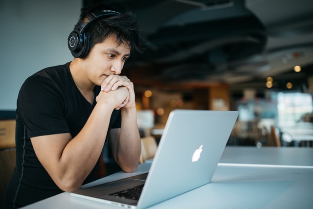 Guy with headphones looking at laptop - small