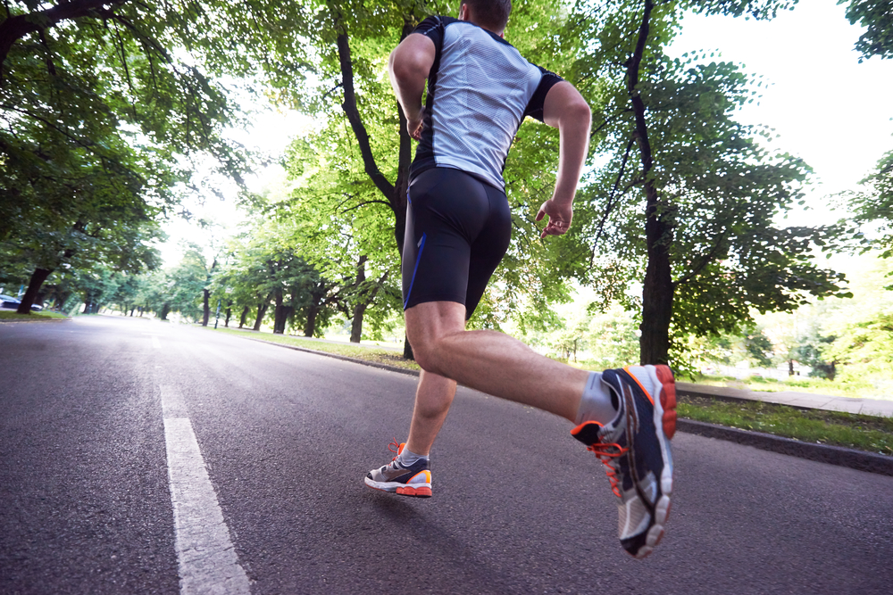 healthy athlete man jogging at morning on empty  roat in the city