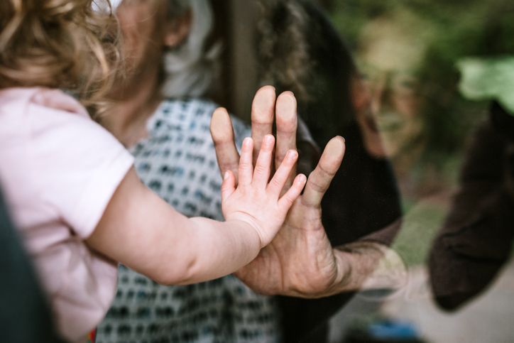 child visiting senior parents but observing social distancing