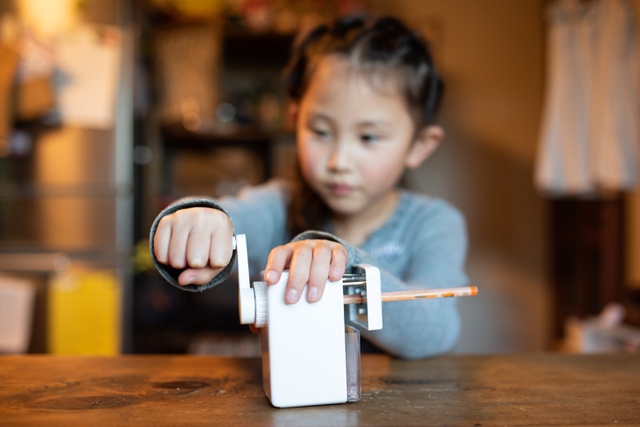girl with autism sharpening a pencil