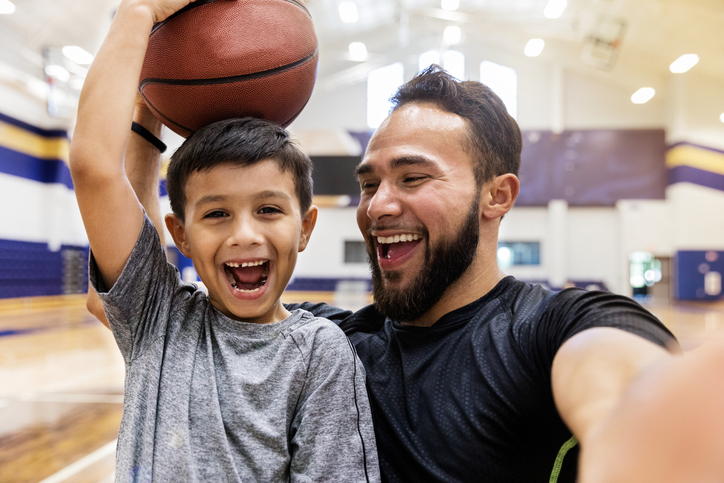 school basketball coach laughs with child with autism
