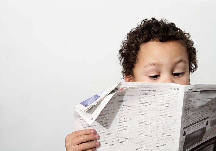 young boy autism reading newspaper