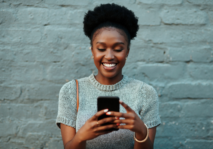 young creative businesswoman using her cellphone during coronavirus lockdown
