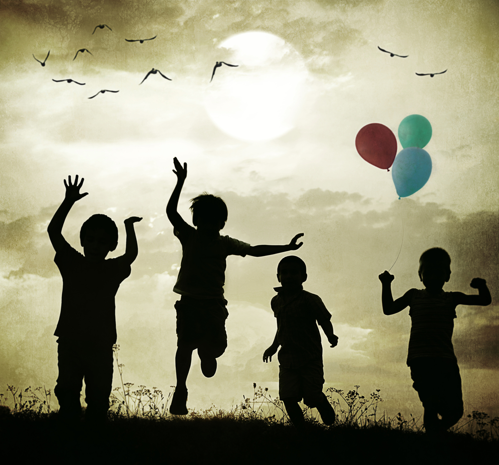 Retro old fashioned photo of children with balloons running on summer meadow