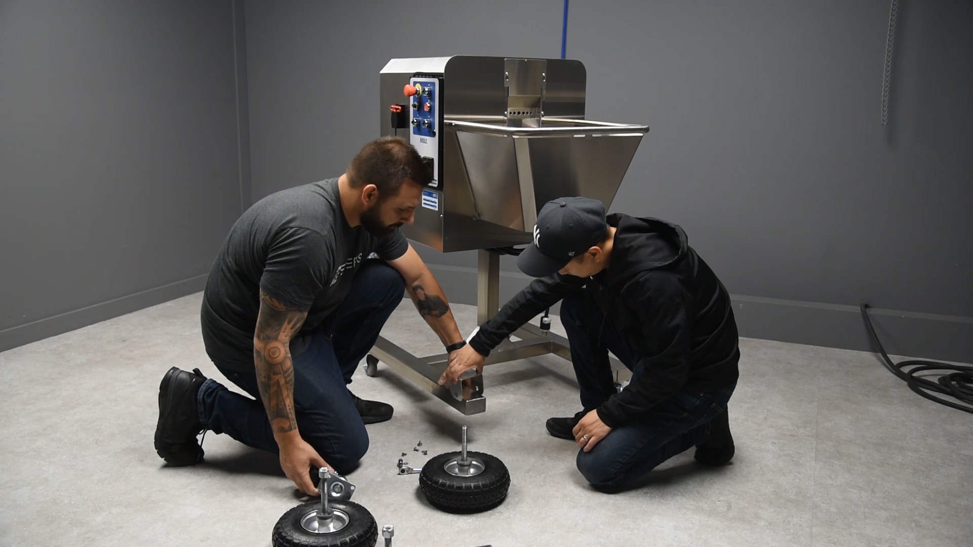 two men changing a wheel on a Mobius Bucker