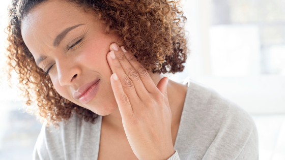 Woman holding jaw with wisdom tooth pain