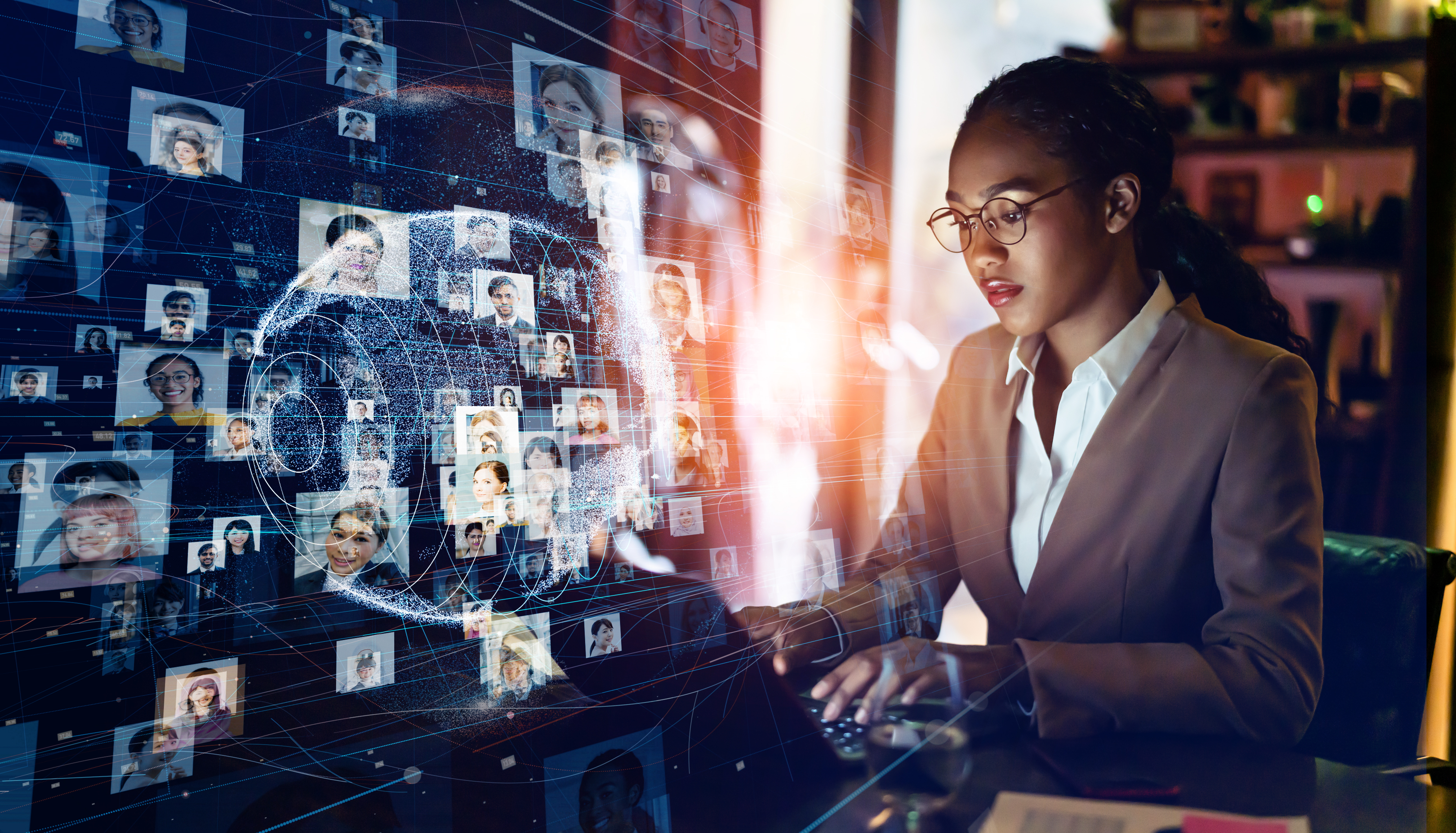 Frau vor einem Computer, aus dem viele Profilbilder herausströmen