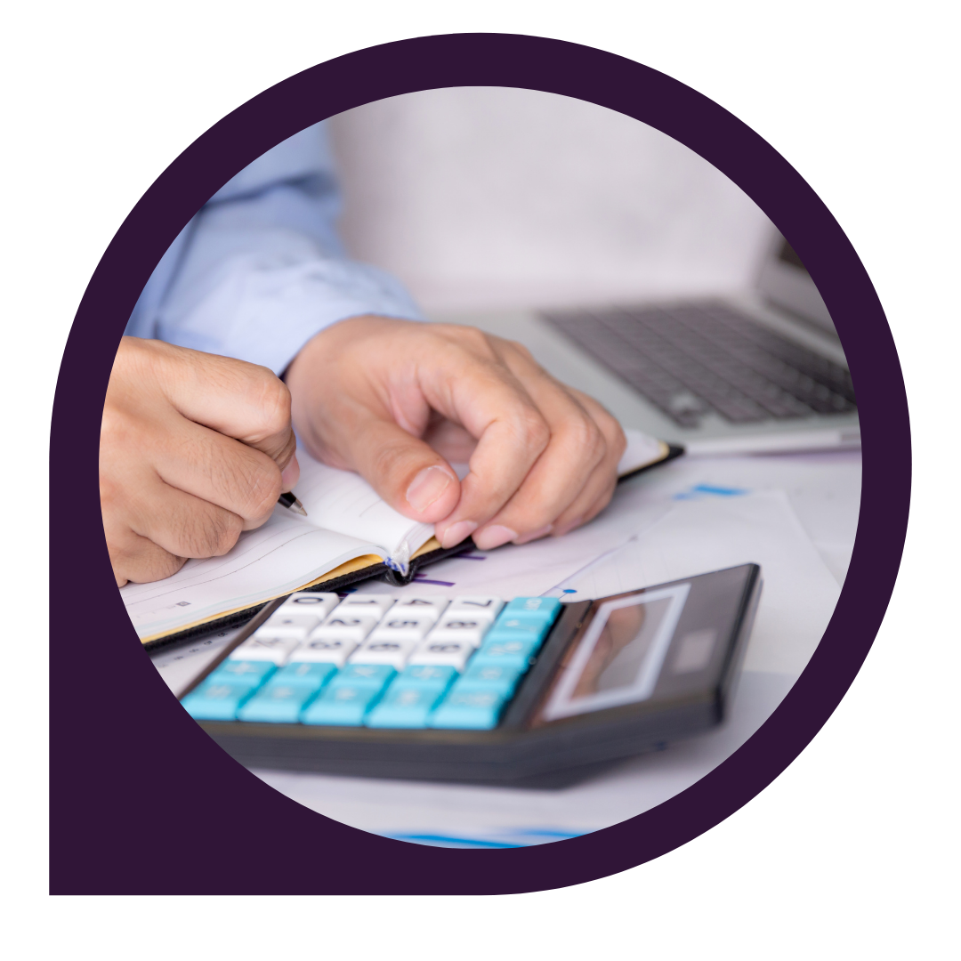 person writing in notebook with calculator