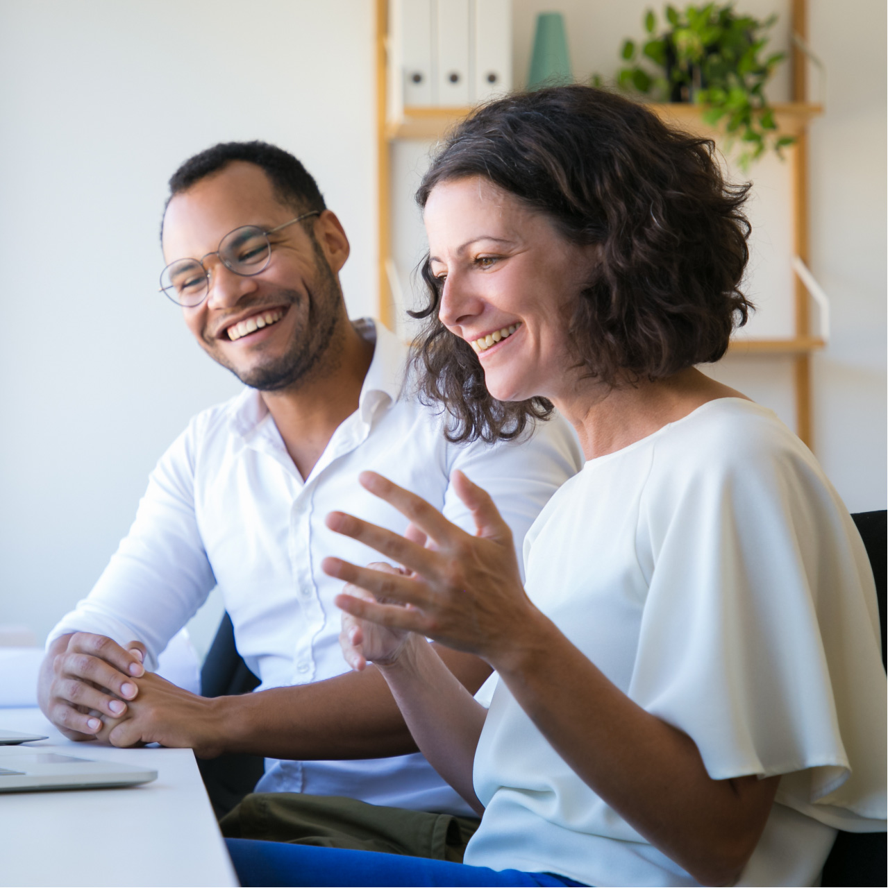 man and woman business partners smiling at computer-2