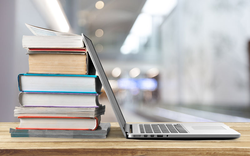 laptop-propped-against-stack-of-books