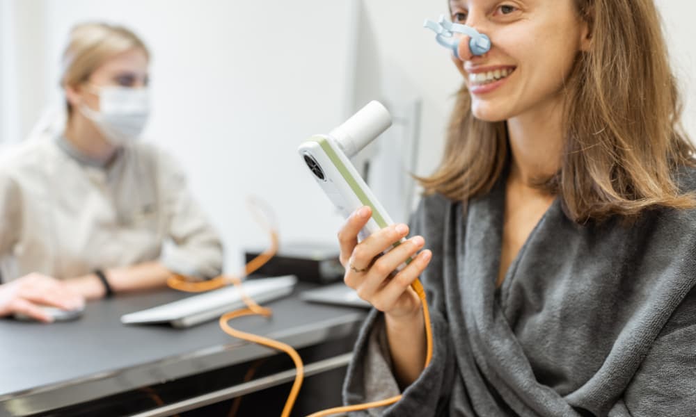 a woman smiling while taking a pulmonary function test