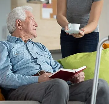 elderly-man-with-book-with-care-giver