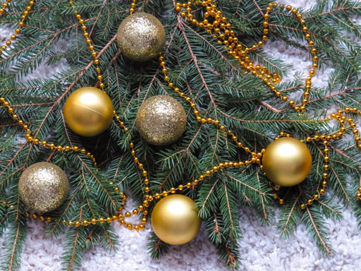 Gold ornaments and garland on pine branches