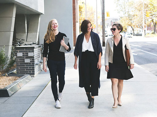 Three women walking to work in business casual attire