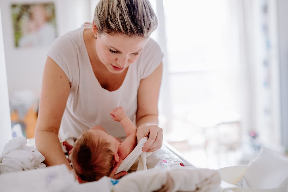 a-beautiful-young-mother-looking-after-a-newborn-b-DX75BHG (1)